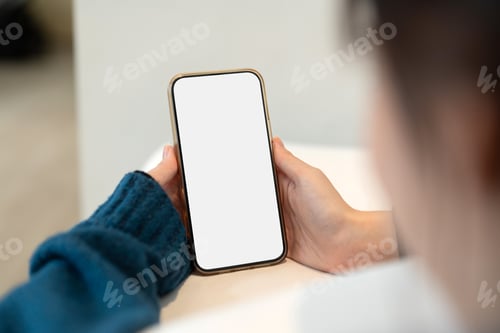 Preview: Young woman using smartphone blank screen frameless modern design while lying on the bed in home