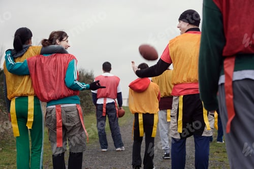 Preview: View from behind of a group of friends getting ready for an American Flag Football game.