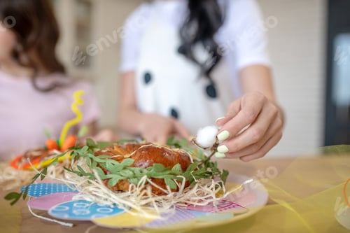 Preview: Close jup picture of womans hand decorating easter bun