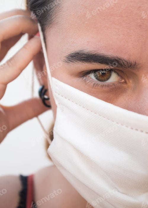 Preview: Shallow focus of a young female with a facemask on - COVID-19