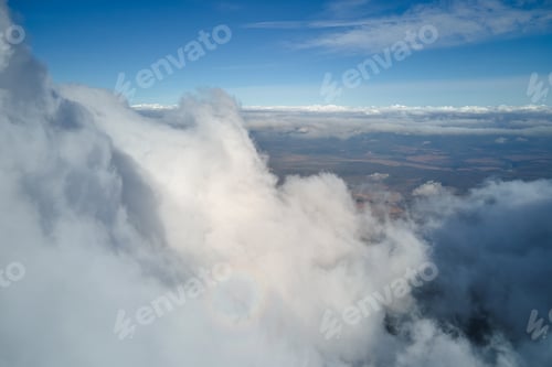 Preview: Aerial view from airplane window at high altitude of earth covered with puffy cumulus clouds