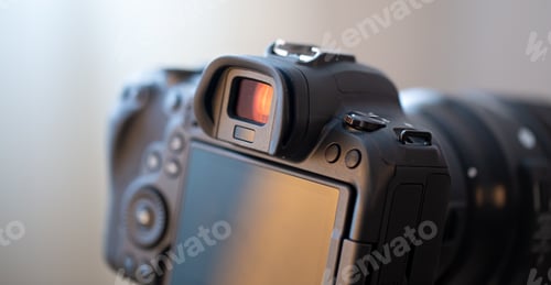 Preview: Close up part of a professional digital camera on a blurred background.