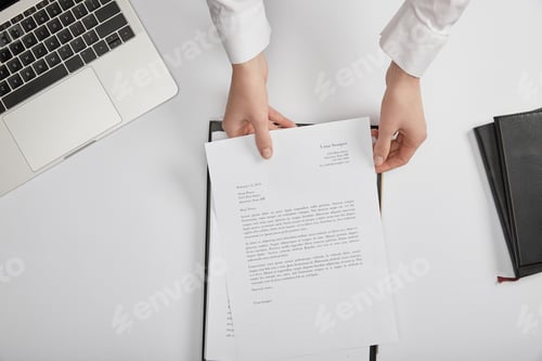 Preview: cropped view of clerk putting document on clipboard at workplace