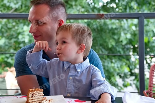Preview: Father and Young Child Enjoy Cake Outdoors Together