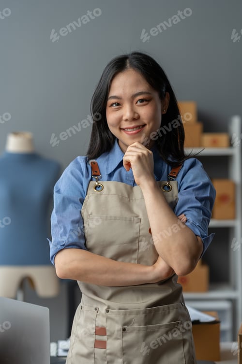 Preview: An Asian SME entrepreneur stands with his arms crossed and smiles for the camera and prepares to del