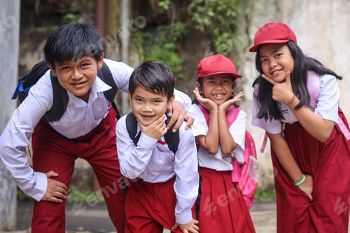 Preview: Group of happy elementary school students looking at camera smiling and showing funny face