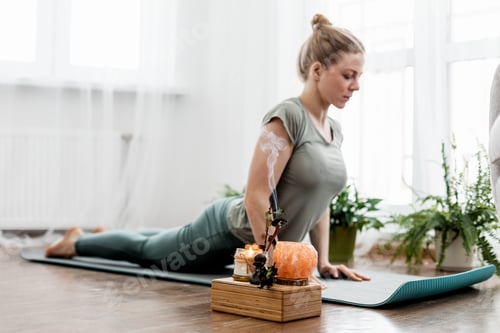 Preview: Beautiful young woman doing exercises and doing yoga at home