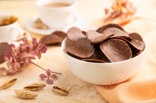 Preview: Chocolate chips with cup of coffee on concrete background. side view, close up, selective focus.