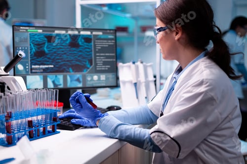 Preview: Scientist typing on laptop holding vacutainer blood healthcare chemistry