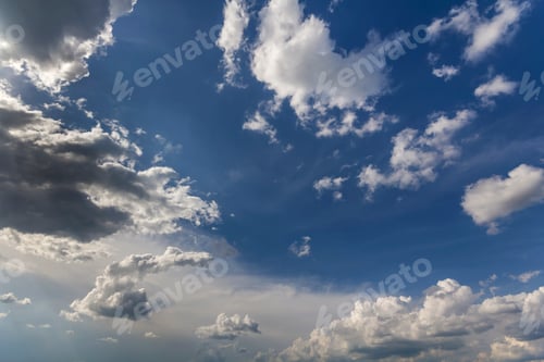 Preview: Fantastic panorama view of bright white puffy clouds lit by sun spreading against deep blue summer