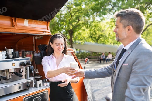 Preview: Businessman buying take away coffee on the street