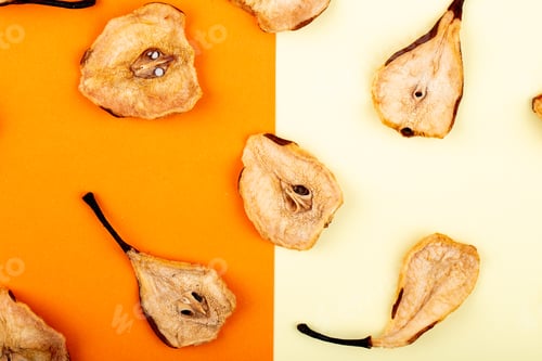 Preview: top view of dried pear slices on white and orange color background