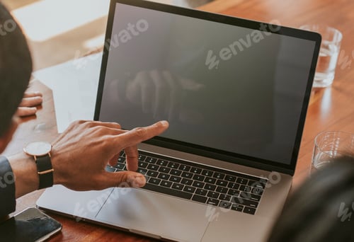 Preview: Businessman working on a laptop in a board meeting