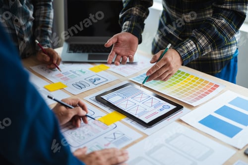 Preview: Close up view of UI developer team brainstorming on their project with laptop, smartphone