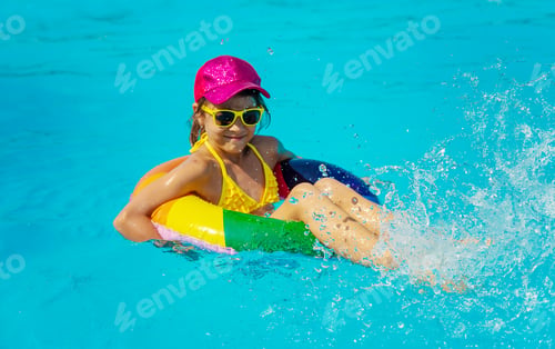 Preview: The child swims in the pool in a circle. Selective focus.