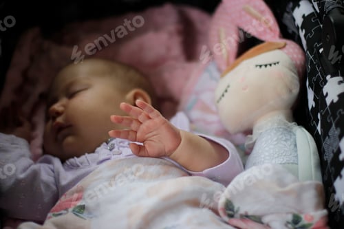 Preview: Sweet little girl sleeping in her stroller, showing her small hand and saying Hello world!