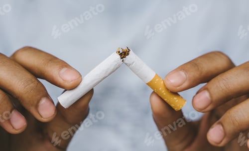 Preview: Cigarette.World No Tobacco Day Concept.Closeup woman holding broken cigarette in hands.