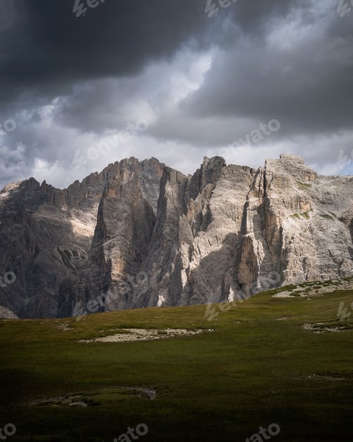 Preview: Beautiful view of huge rocks with a field under the cloudy sky