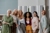 Preview: Group of happy mature women looking at camera while standing in the office together