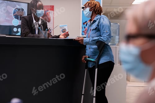 Preview: Afro receptionist at health center attending woman on crutches