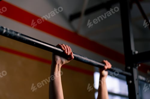 Preview: close up in the gym coach girl in black leggings and a top weighs on the horizontal bar