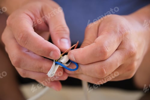 Preview: Young man hands repairing or splicing wires.