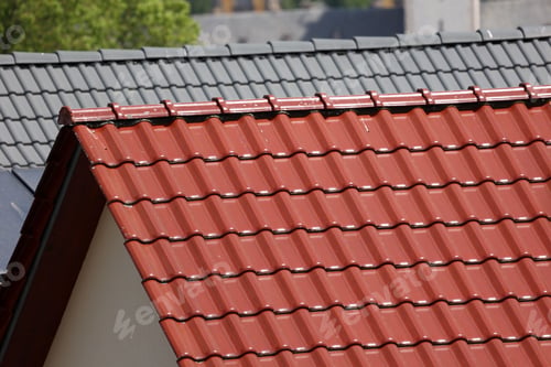 Preview: Closeup of a typical tiled roof and chimney against blue sky