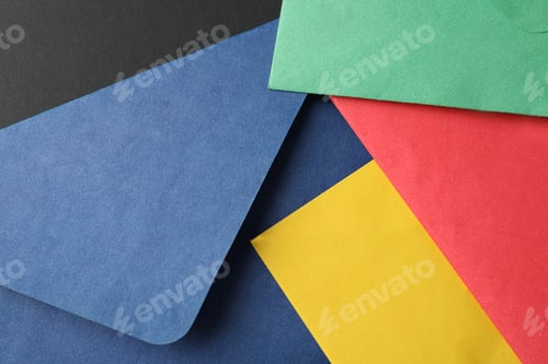 Preview: Colorful paper envelopes on black background, closeup
