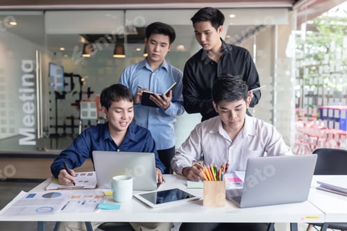 Preview: Group of young Asian men who using laptop computer to discuss and talking at office.