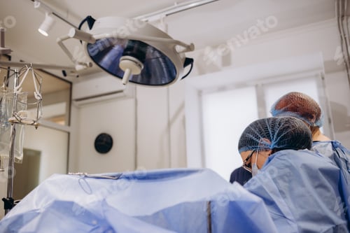 Preview: Doctor during surgery in operating room. Professional female doctor performing operation in surgery