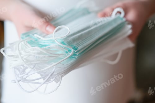 Preview: doctor's hand holding medical face masks.