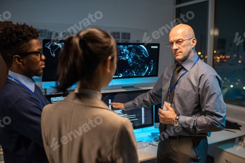 Preview: Bald mature director of software company giving instructions to his subordinates