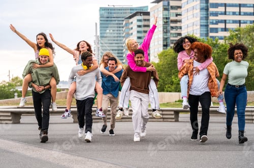 Preview: Happy playful multiethnic group of young friends bonding outdoors