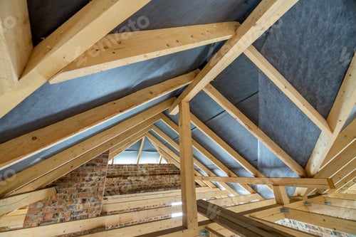 Preview: Attic space of a building under construction with wooden beams of a roof structure and brick walls