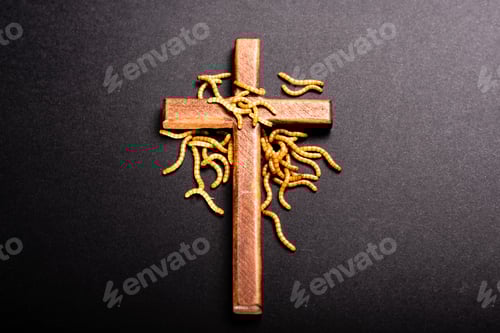Preview: Christian wooden cross attacked by worms that rot the roots of Christianity, a symbolic metaphor.