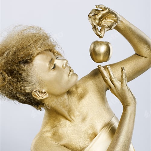 Preview: Portrait Of Girl With Golden Bodyart Posing With Golden Apple In Her Hands On Gray