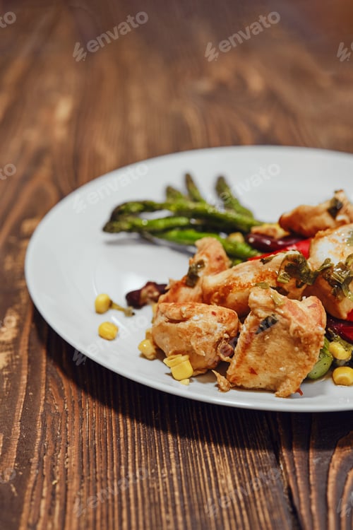 Preview: Close-up view of spicy chicken ragout with vegetables and fried asparagus