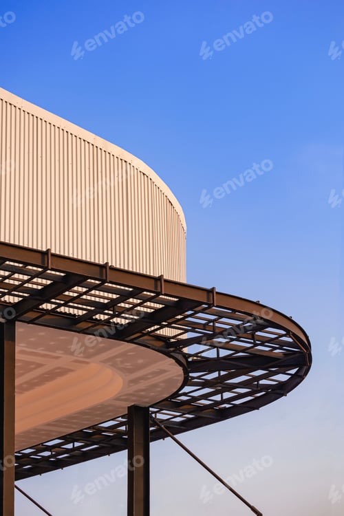 Preview: Curved metal awning structure with corrugated steel roof of modern building is under construction