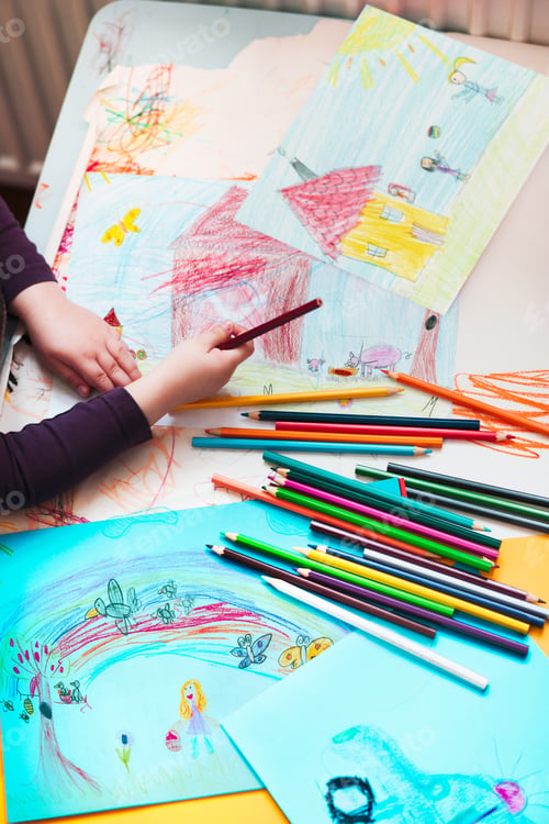 Preview: Child drawing pictures. Many drawings crayons scattered on desktop. Creating artwork in preschool