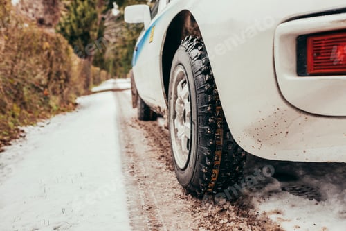 Preview: Low angle view close up classic car driving in winter snowy road
