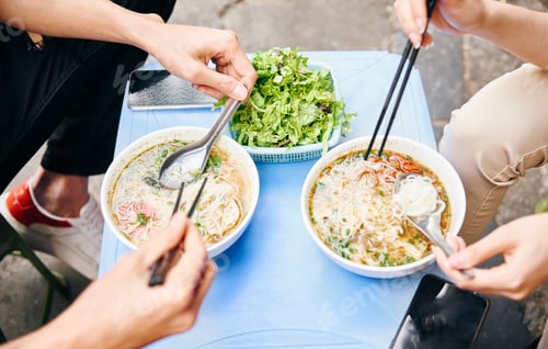 Preview: Close up of couple tasting oriental Vietnamese food