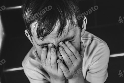 Preview: Little boy hiding his face with his hands.