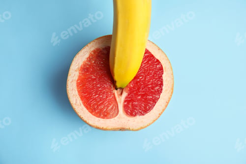 Preview: Fresh grapefruit and banana on blue background, top view. Sex concept