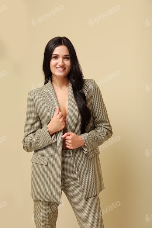 Preview: Beautiful woman in formal suit on beige background