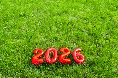 Visualização: Números de balões vermelhos de 2026 na grama verde. Conceito de celebração de ano novo.