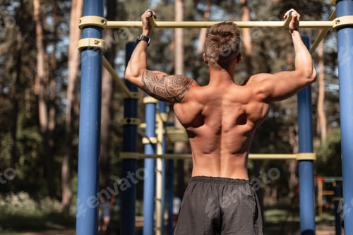 Preview: Cool handsome healthy muscular athletic man training outdoors