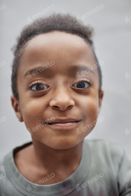 Preview: Portrait of Smiling Black Boy Staring at Camera in Studio on Grey Background