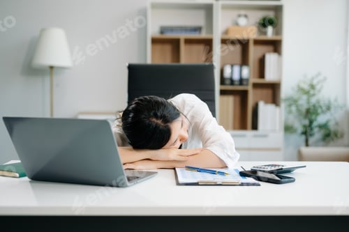 Preview: Frustrated young businesswoman working on a laptop computer sitting at his working place