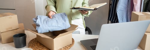 Preview: Asian business owner working at home with packing box of her online store prepare to deliver product