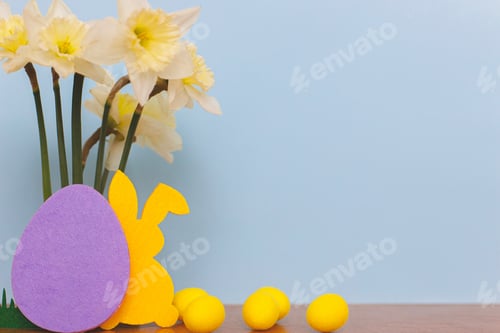 Preview: Colorful Easter bunnies, eggs, daffodils on blue background with space for text. Happy Easter!
